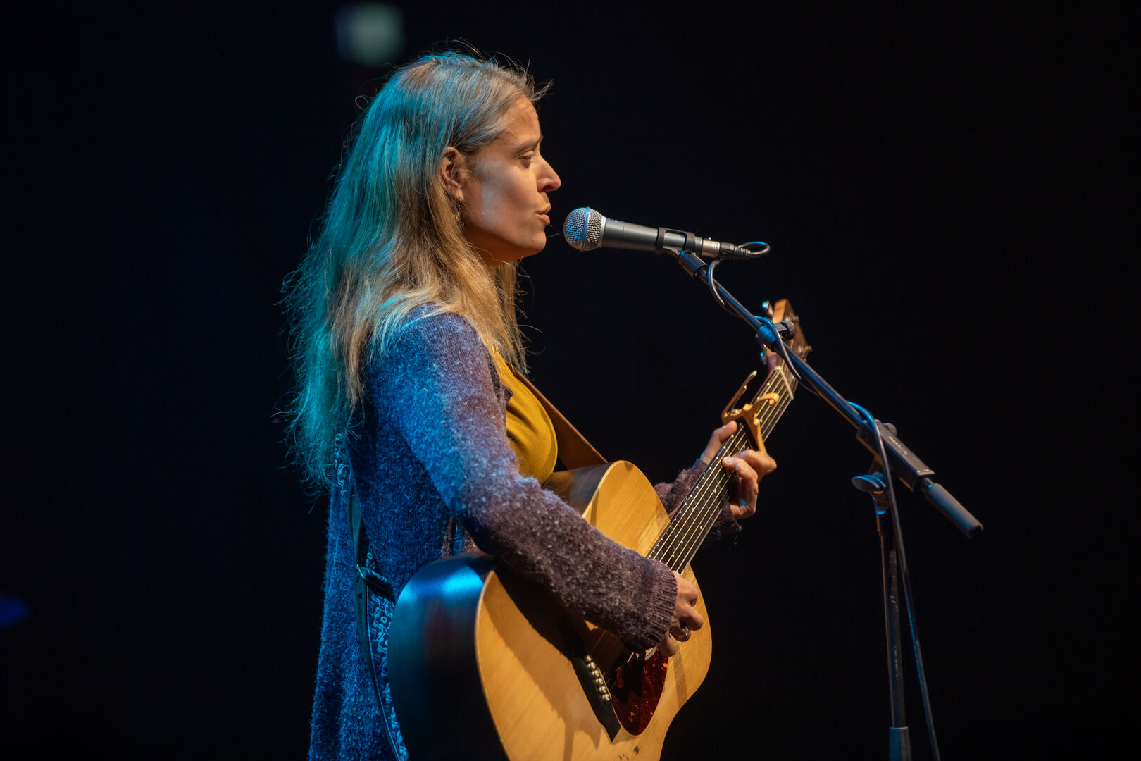 Rian Reversed speelt de gitaar en zingt in een microfoon