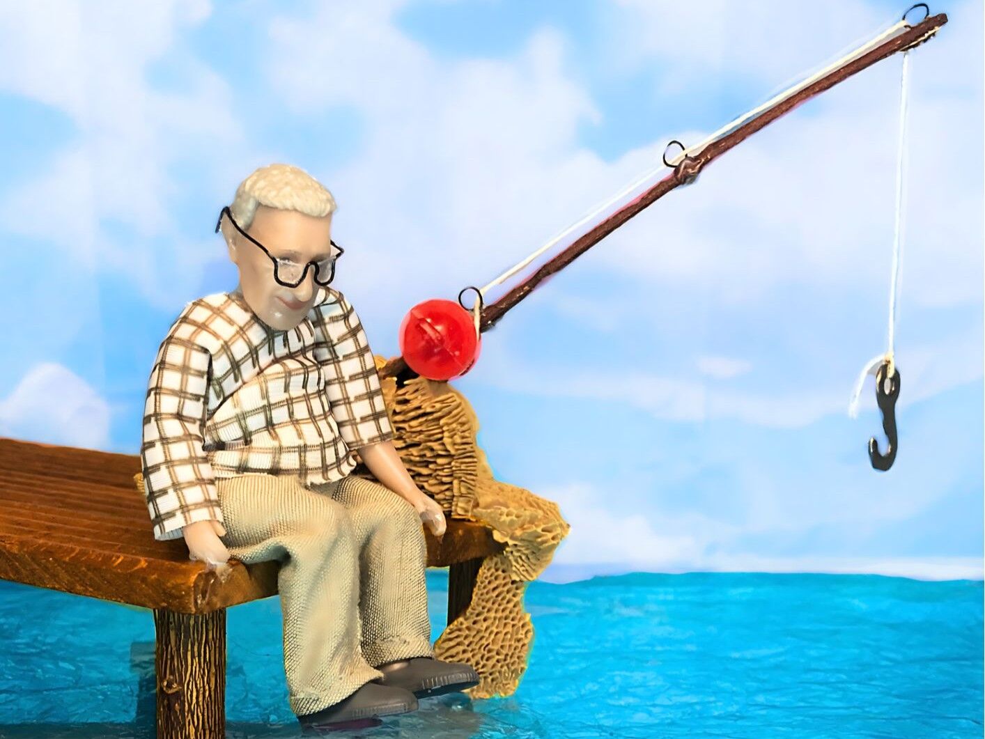 Poppetje aan het vissen bij het water