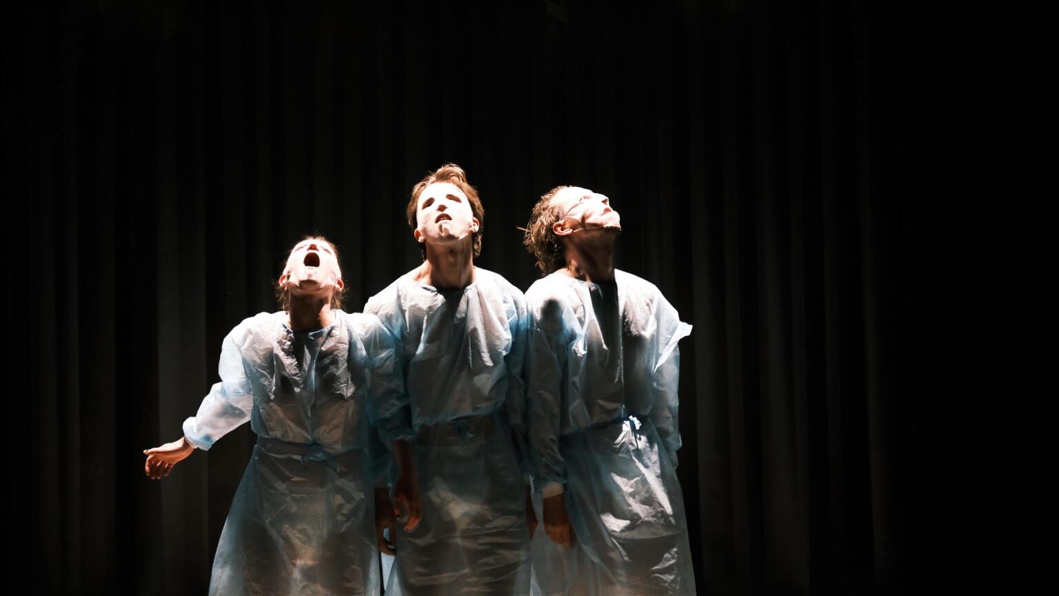 drie spelers in chemiepakken houden elkaar vast