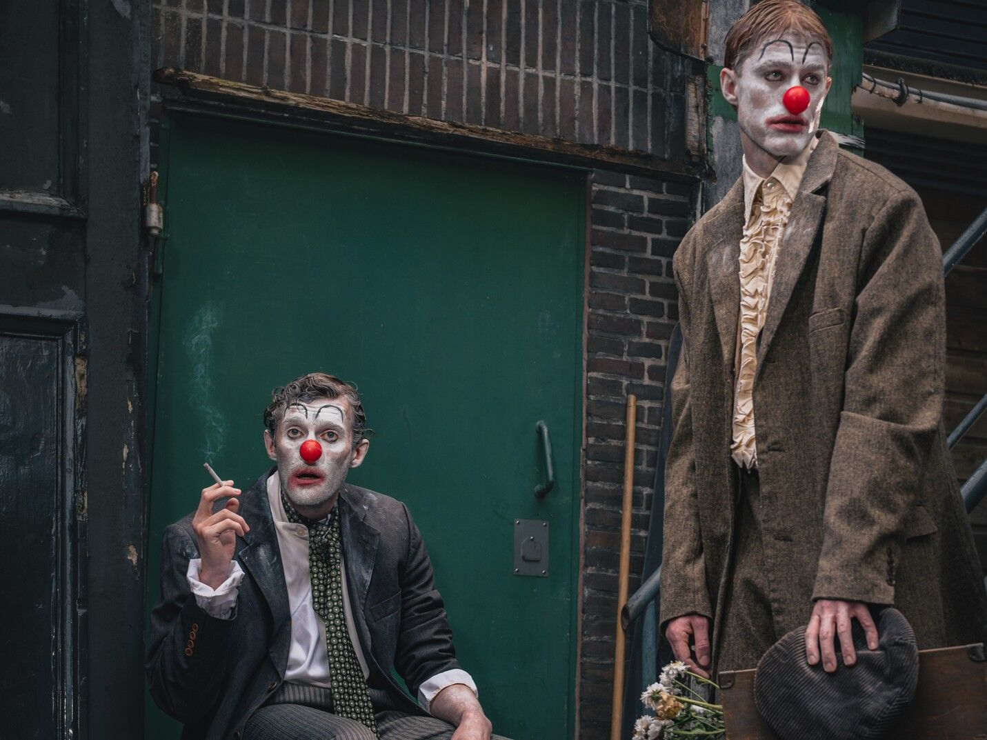 Twee sombere clowns in een grauwe steeg