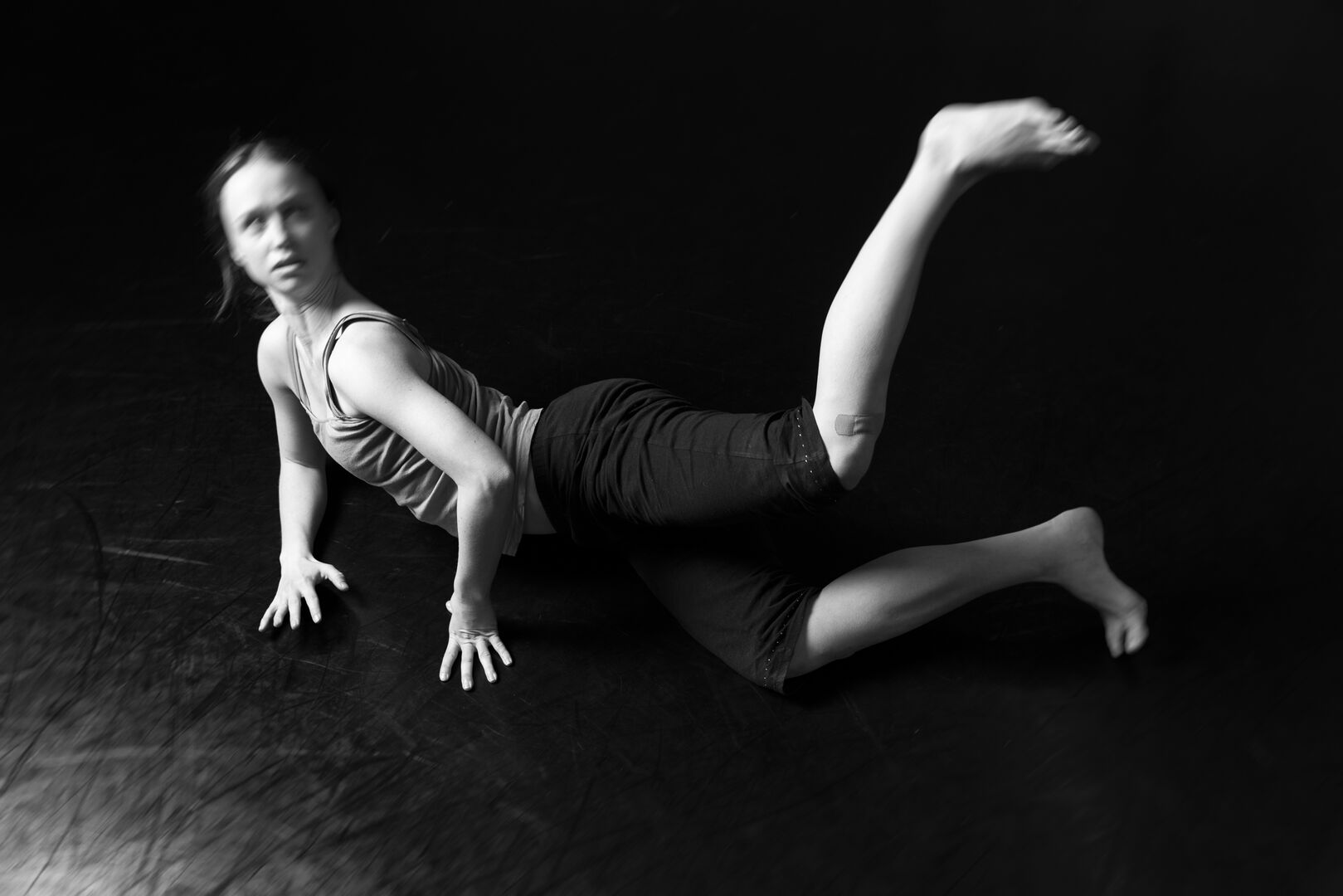 Zwart wit beeld van maker die op de grond danst