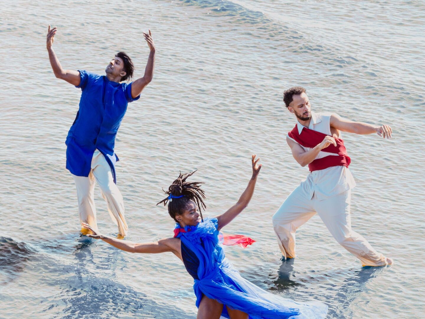 Drie dansers die dansen in het water