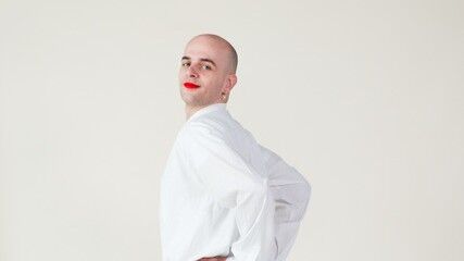 Kale man heeft is half gedraaid en lacht met rode lipstick op 